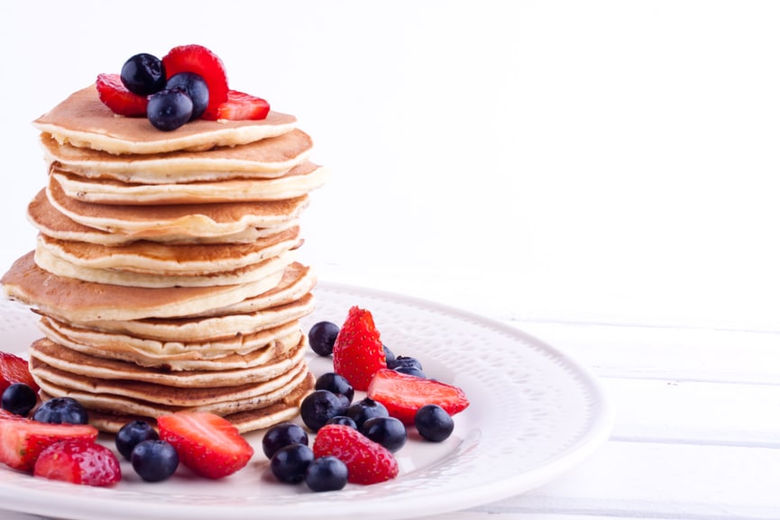 Stapel mit Pancakes und Früchten auf einem Teller